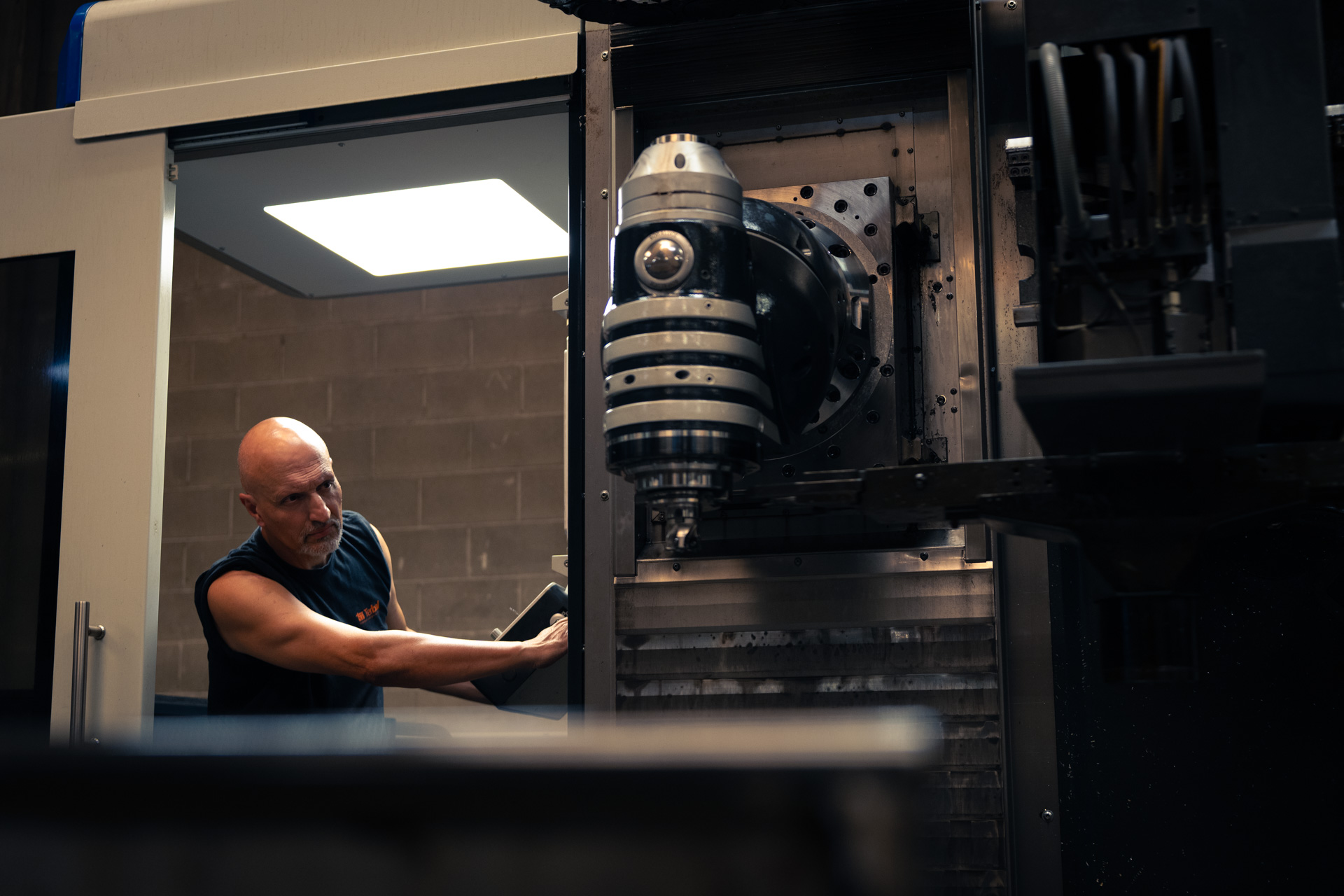 A team member operating a milling machine